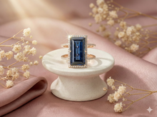 The Rose Gold Royal Blue Emerald Cut Halo Ring